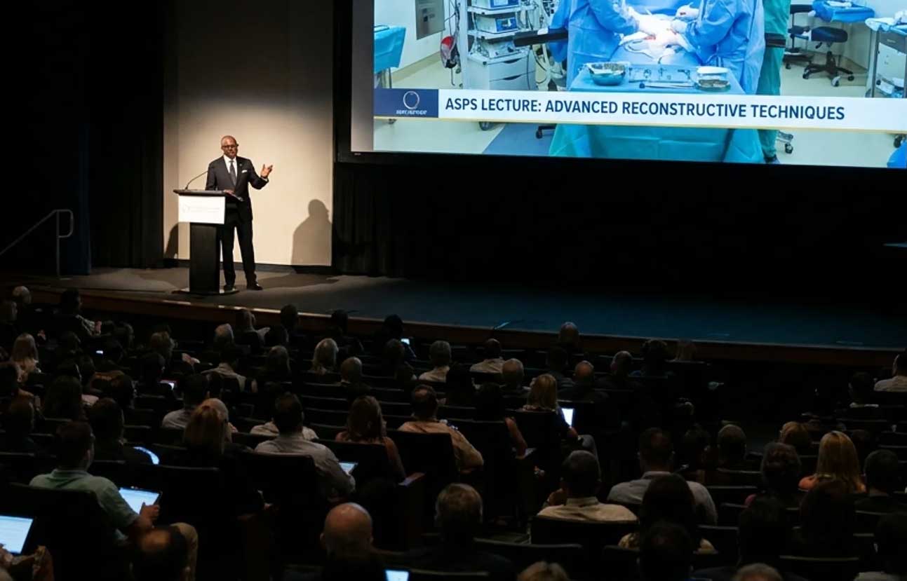 Distinguished surgeon at a lectern delivering a keynote — the apex stage that defines the next ladder of the career